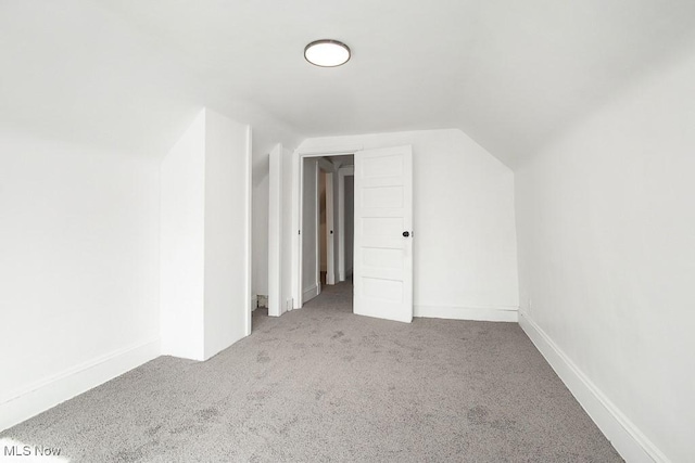 additional living space with carpet flooring, vaulted ceiling, and baseboards