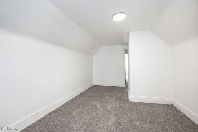 bonus room featuring lofted ceiling, carpet flooring, and baseboards