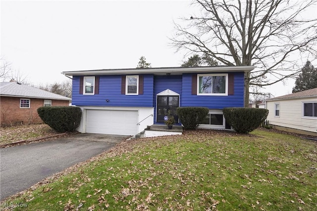 split foyer home with a garage, driveway, and a front yard