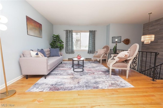 living room featuring an inviting chandelier, wood finished floors, and baseboards