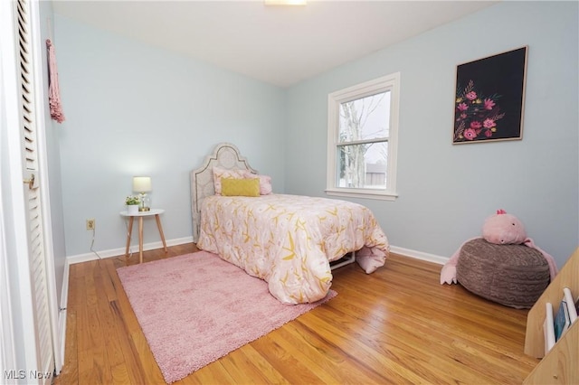 bedroom featuring wood finished floors and baseboards