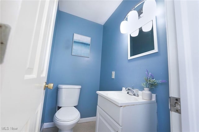 bathroom with baseboards, vanity, and toilet