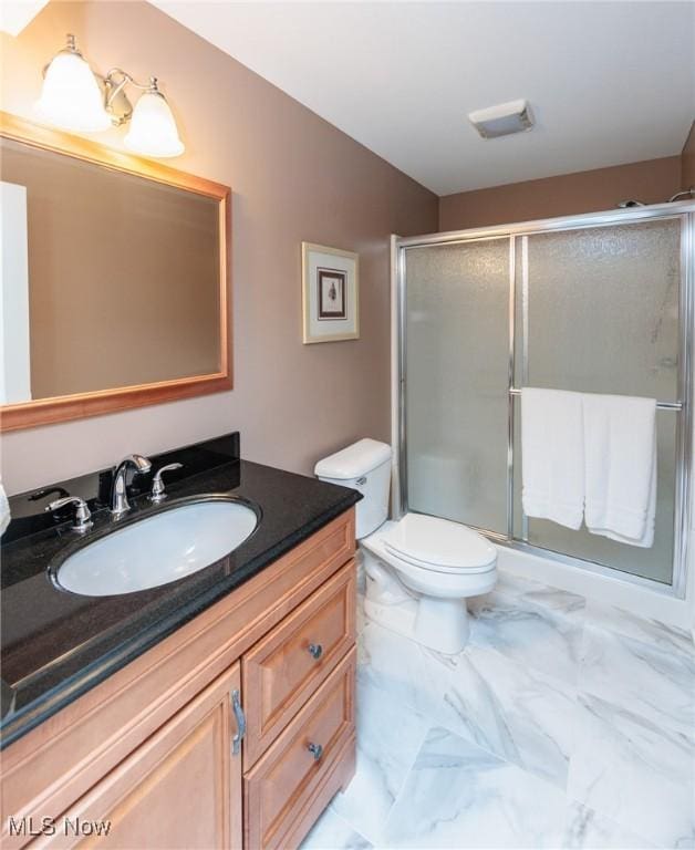 bathroom with marble finish floor, visible vents, toilet, a stall shower, and vanity