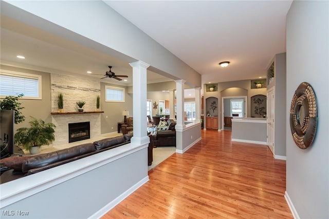 hallway featuring ornate columns, baseboards, light wood finished floors, and recessed lighting