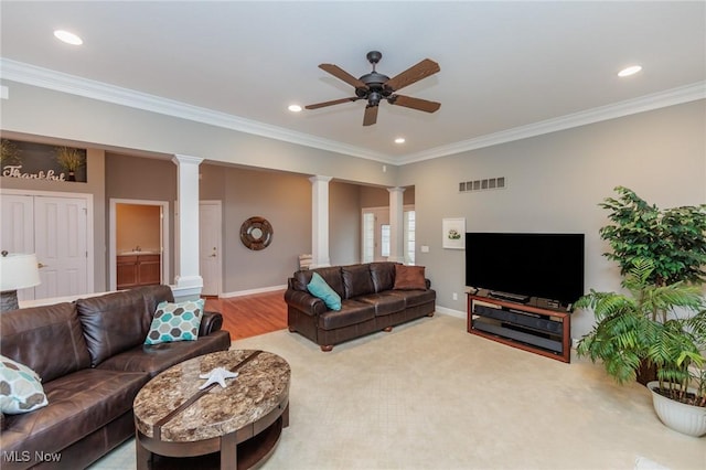 living area with ceiling fan, crown molding, visible vents, and ornate columns