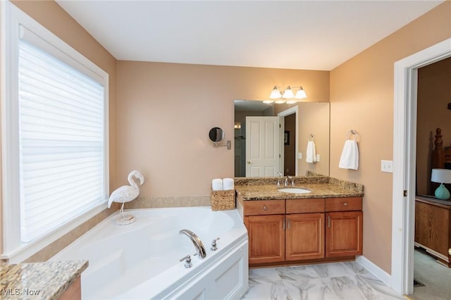 full bath with a garden tub, marble finish floor, a wealth of natural light, and vanity