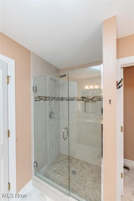 bathroom featuring a stall shower and baseboards