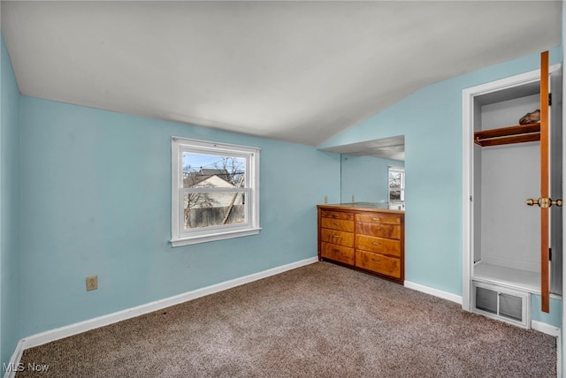 unfurnished bedroom with visible vents, baseboards, vaulted ceiling, carpet flooring, and a closet