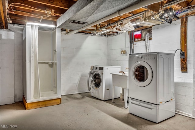 laundry room with a sink, laundry area, washing machine and dryer, and visible vents