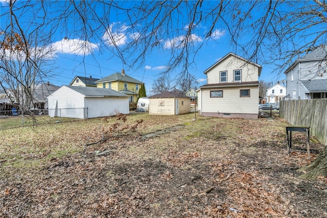 view of yard with a storage unit, a residential view, fence, and an outdoor structure