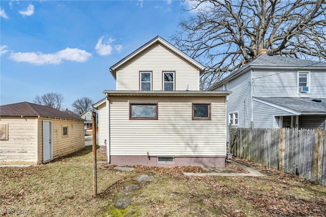 rear view of house featuring an outbuilding, cooling unit, and fence