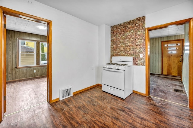 interior space featuring a paneled ceiling, dark wood-style flooring, visible vents, and baseboards