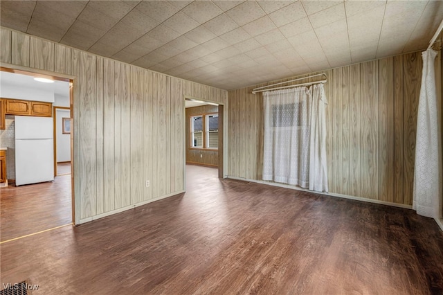 unfurnished room with baseboards and wood finished floors