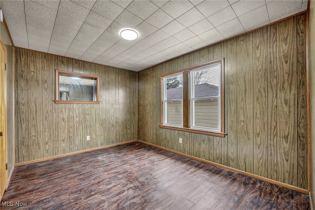 unfurnished room featuring baseboards and wood finished floors