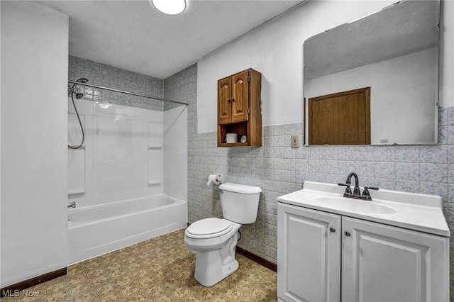 bathroom with a textured ceiling, shower / tub combination, toilet, vanity, and tile walls