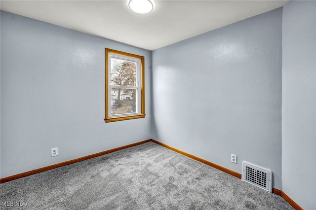 carpeted empty room featuring visible vents and baseboards