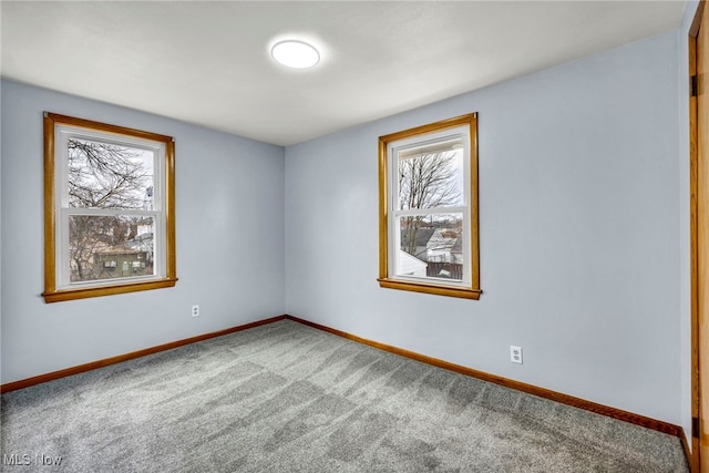 empty room with carpet floors, plenty of natural light, and baseboards