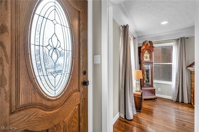 foyer entrance featuring a textured ceiling, dark wood-type flooring, and baseboards