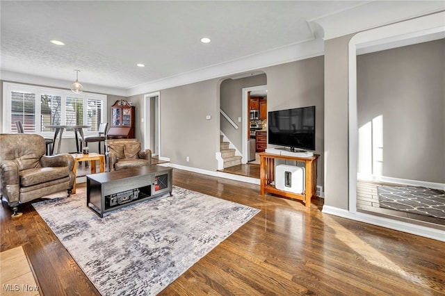 living room featuring dark wood-style floors, recessed lighting, baseboards, and stairs