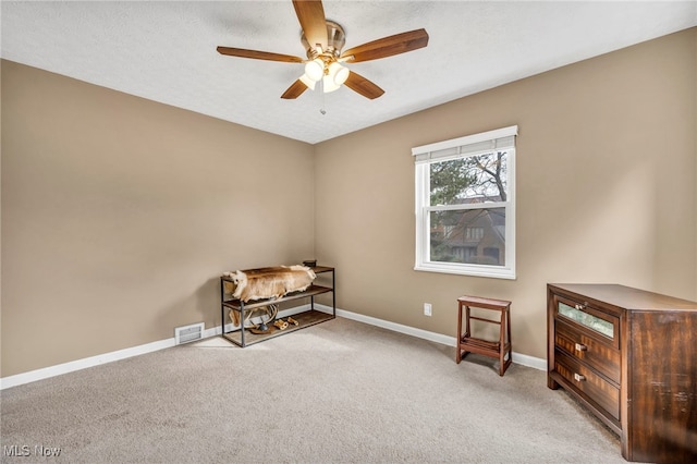 miscellaneous room featuring baseboards, visible vents, a ceiling fan, light colored carpet, and a textured ceiling