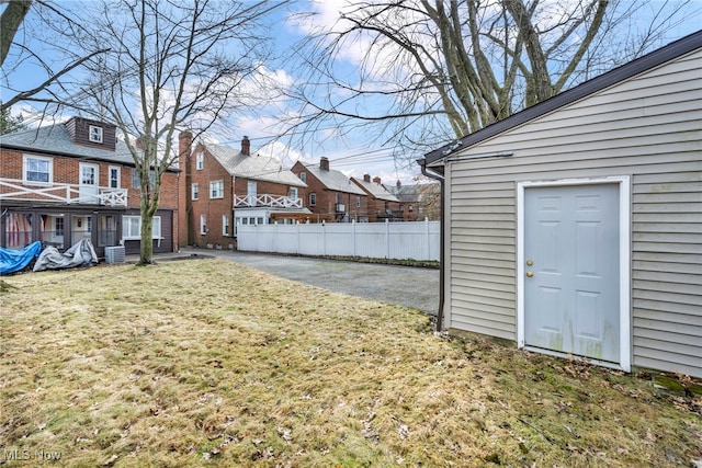 view of yard featuring central air condition unit, a residential view, and fence