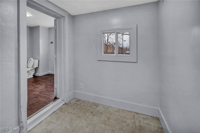 unfurnished room featuring baseboards