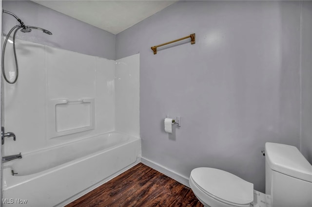 full bath with  shower combination, wood finished floors, toilet, and baseboards