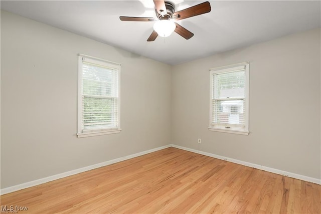 unfurnished room with a healthy amount of sunlight, light wood-style floors, ceiling fan, and baseboards