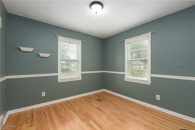 spare room featuring baseboards and wood finished floors