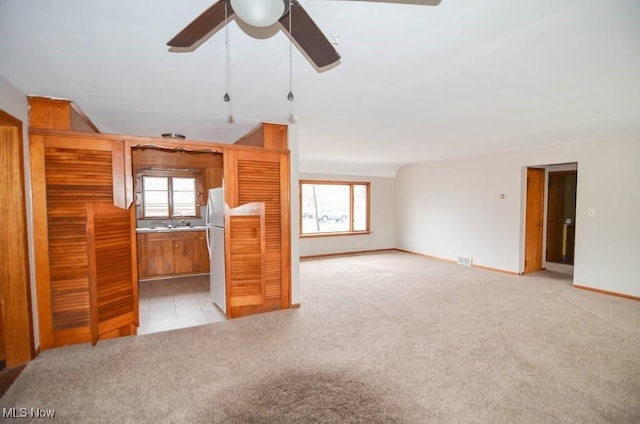 interior space with light carpet, ceiling fan, visible vents, and a sink