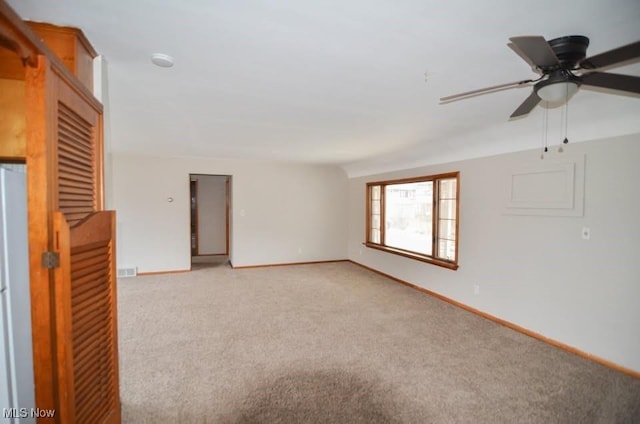 unfurnished room with visible vents, baseboards, a ceiling fan, and light colored carpet