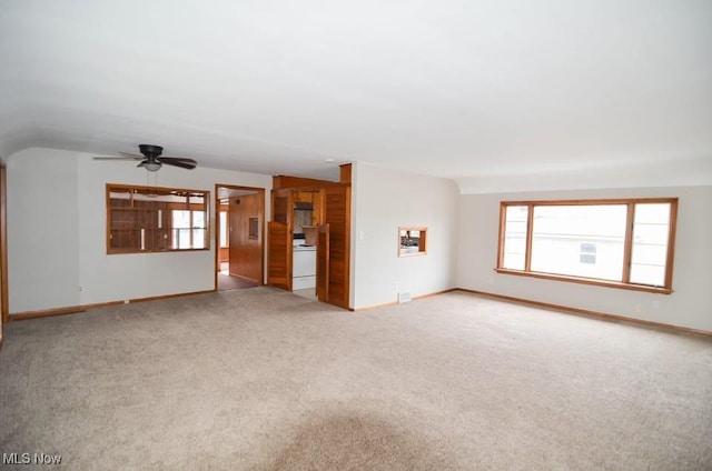 unfurnished living room featuring light carpet, lofted ceiling, and baseboards