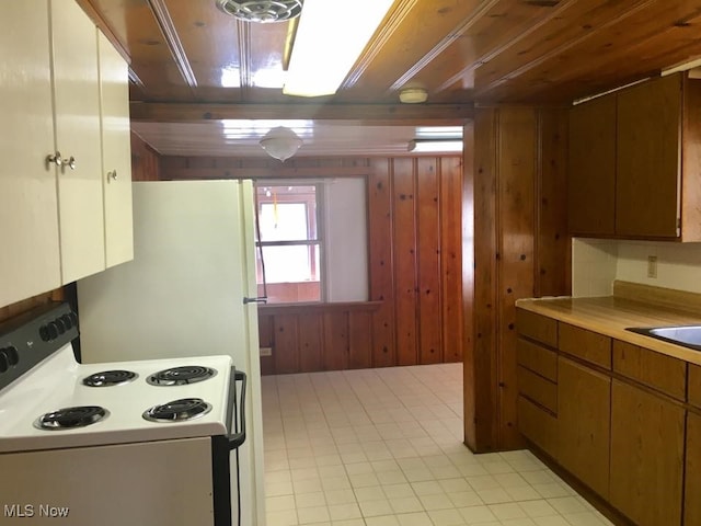 kitchen featuring wooden ceiling, wooden walls, light countertops, and white range with electric cooktop