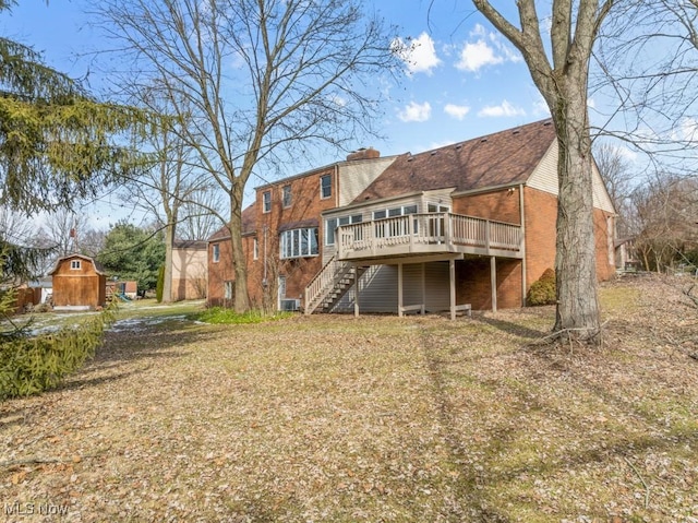 back of house featuring brick siding, stairway, and a wooden deck