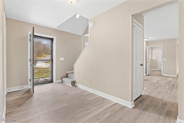 entrance foyer featuring stairs, wood finished floors, visible vents, and baseboards