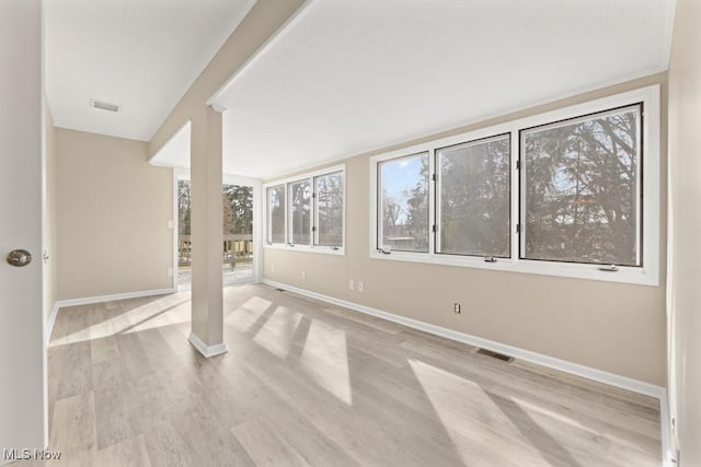 interior space with light wood-type flooring, baseboards, and visible vents