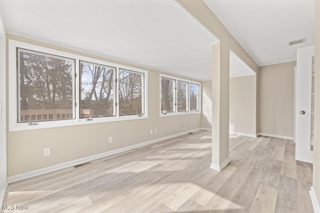 below grade area with baseboards, visible vents, and light wood finished floors