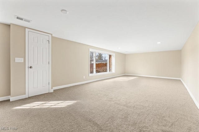 carpeted spare room featuring visible vents and baseboards