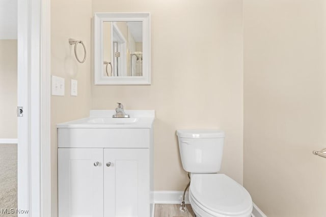 bathroom featuring vanity, toilet, and baseboards