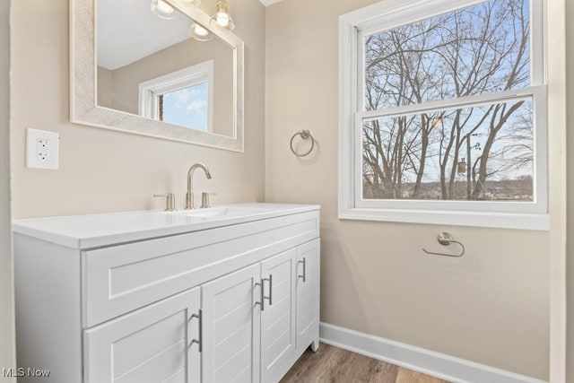 bathroom featuring vanity, baseboards, and wood finished floors