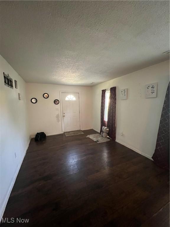 entryway featuring a textured ceiling, baseboards, and wood finished floors