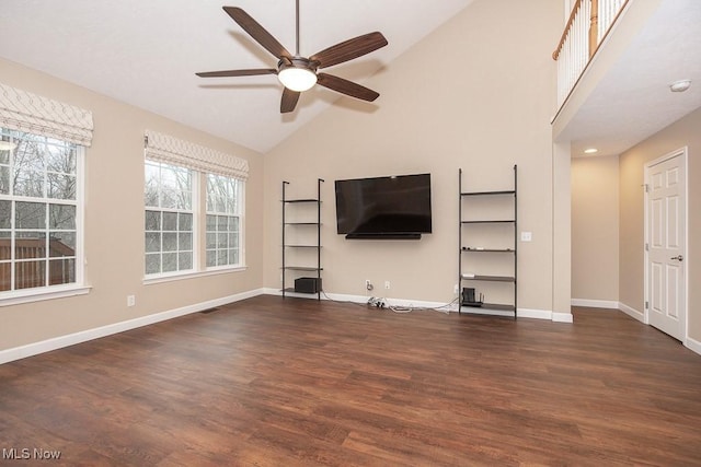 unfurnished living room featuring high vaulted ceiling, a ceiling fan, baseboards, and wood finished floors