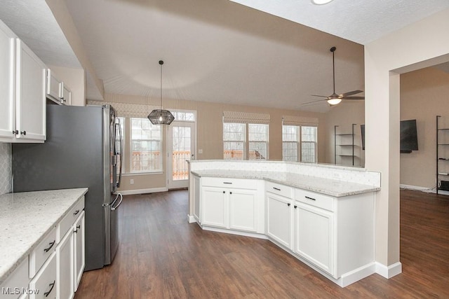 kitchen with white cabinetry, vaulted ceiling, dark wood-type flooring, and freestanding refrigerator