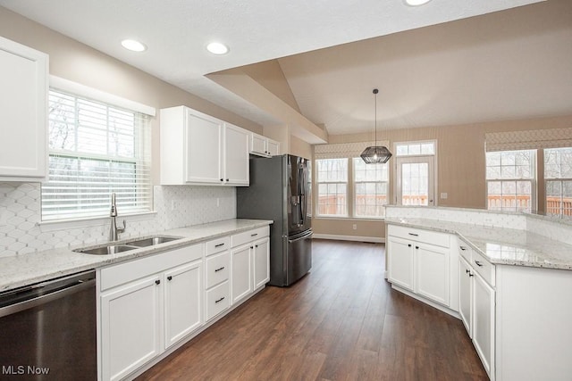 kitchen with vaulted ceiling, dark wood-style floors, white cabinets, stainless steel appliances, and a sink