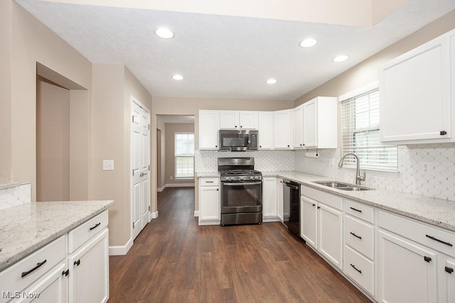 kitchen featuring a healthy amount of sunlight, dark wood-style floors, appliances with stainless steel finishes, and a sink