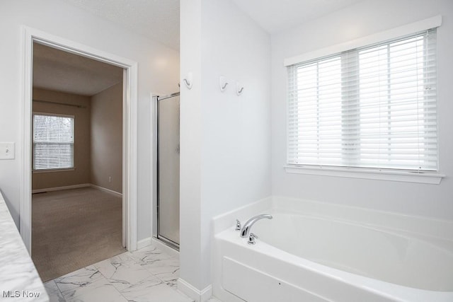 bathroom with plenty of natural light, marble finish floor, a textured ceiling, and a shower stall