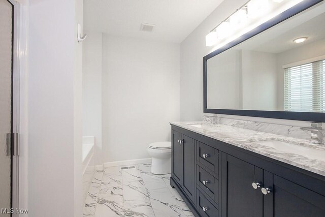 bathroom featuring marble finish floor, toilet, baseboards, and a sink