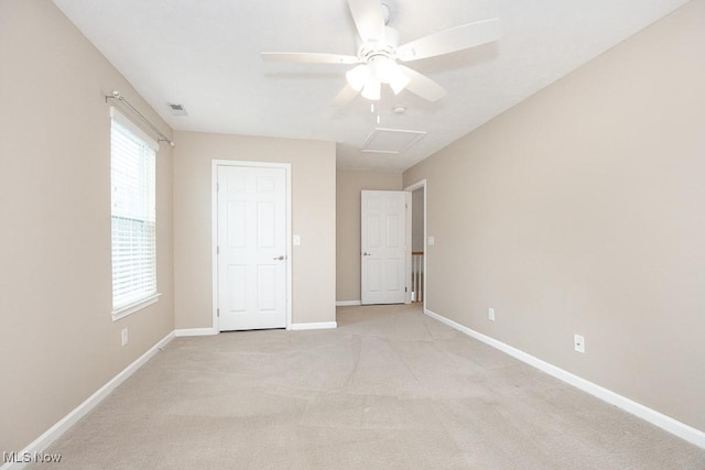 unfurnished bedroom featuring visible vents, baseboards, light colored carpet, and attic access