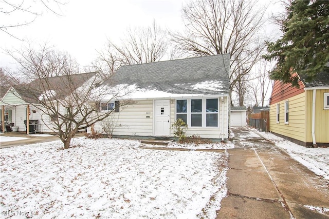 view of front of house with a garage, roof with shingles, and an outdoor structure