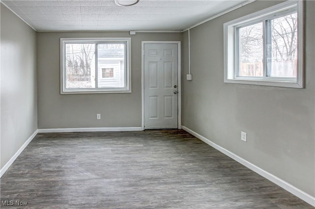 unfurnished room with baseboards and wood finished floors